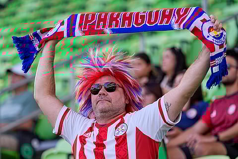 A fan cheers match between Costa Rica and Paraguay